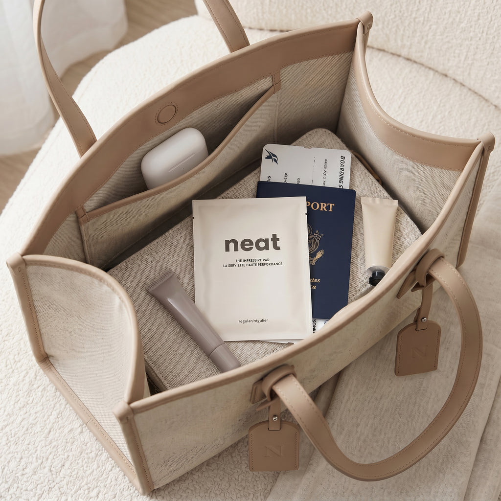 modern discreet packaging of neat menstrual care products inside a beige travel tote bag